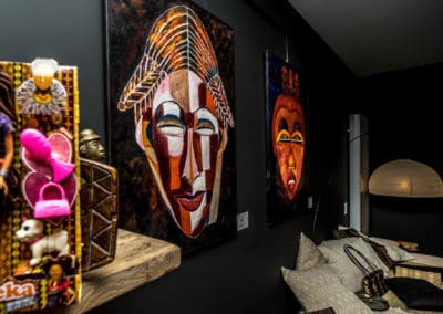 Tableau de masques africains colorés aux murs du Muntu Concept Store